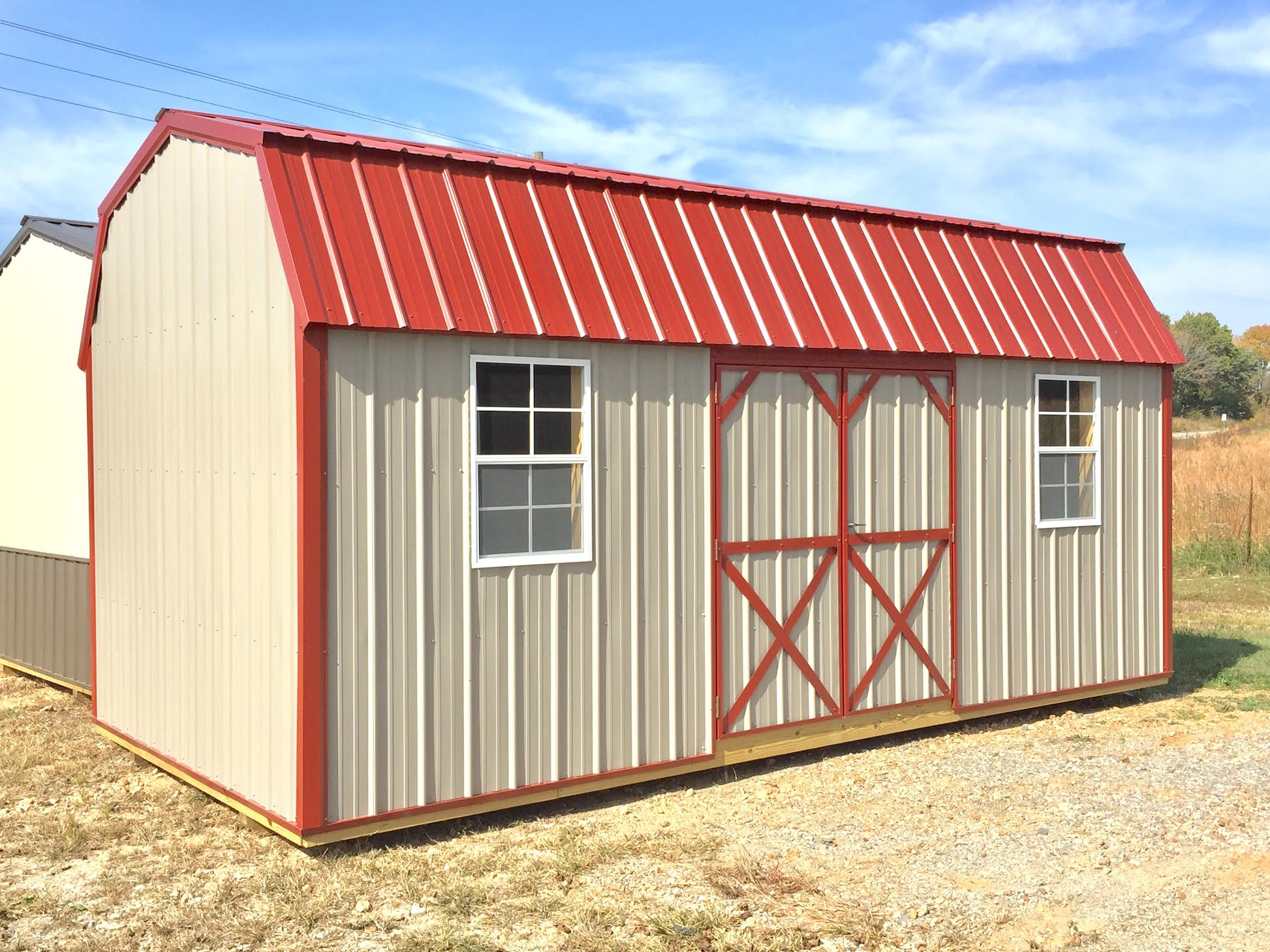 Tan all metal garden shed with red trim and roof