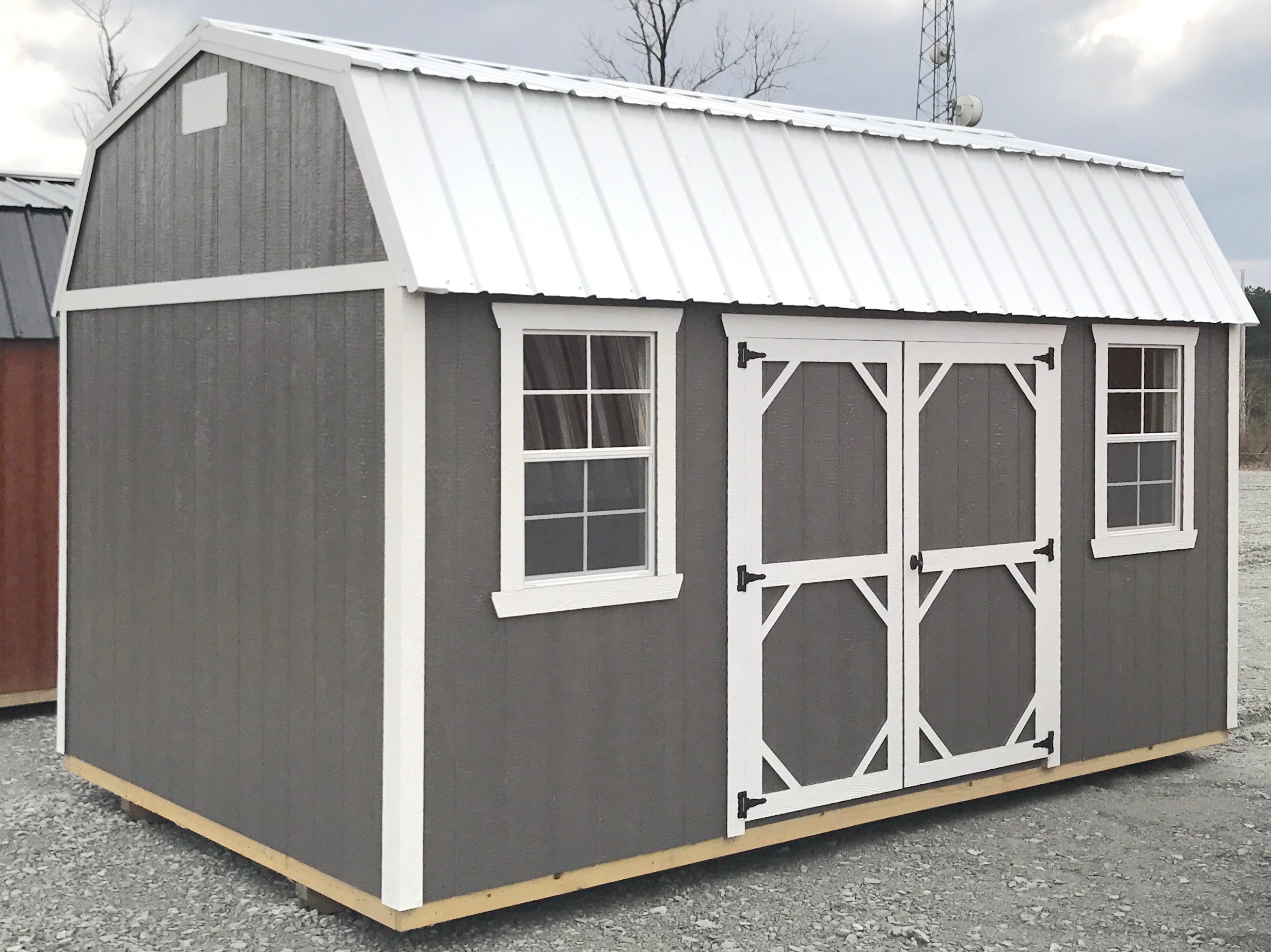 Gray urethane side lofted barn with white trim and metal roof