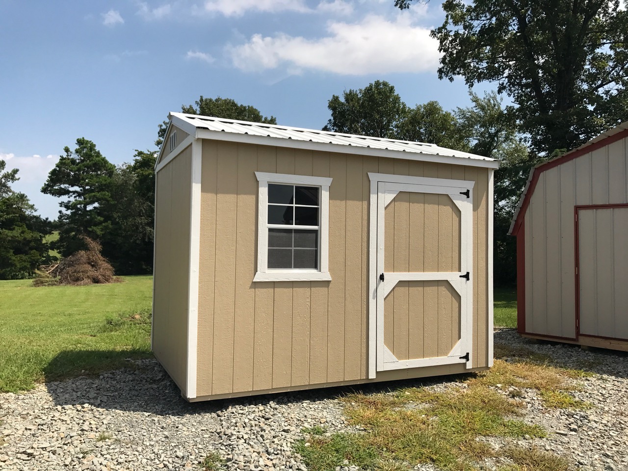 Small tan express series garden shed with white trim and metal roof