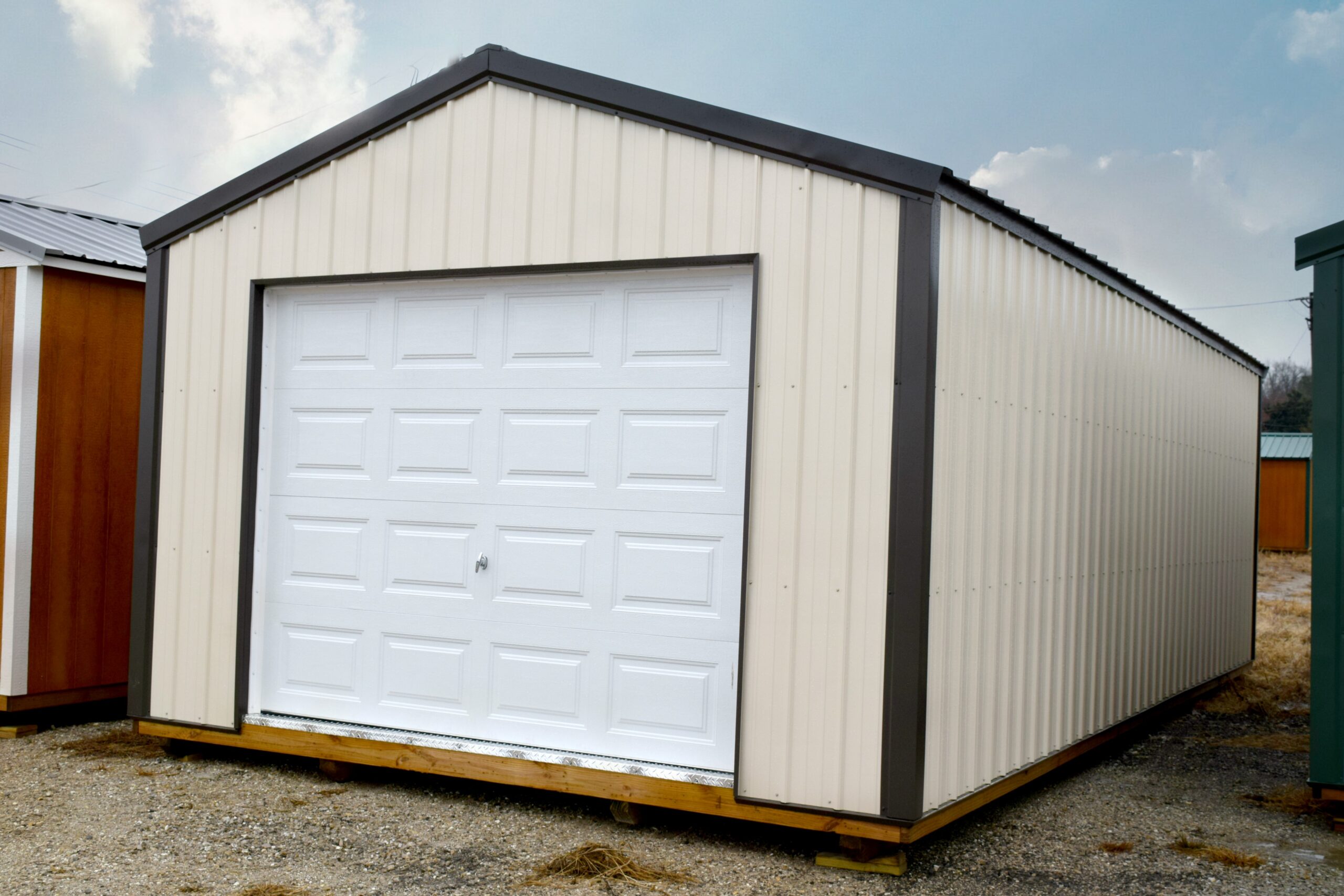 Tan metal garage with white door, black trim and roof