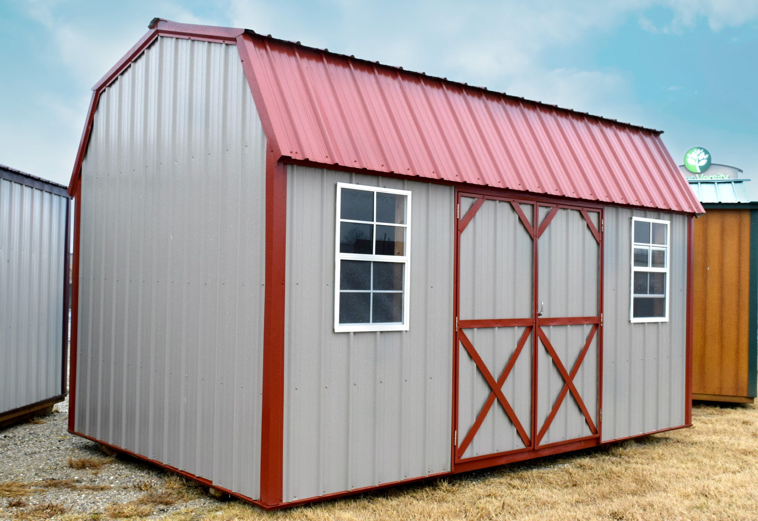 Gray side lofted shed with red trim and metal roof