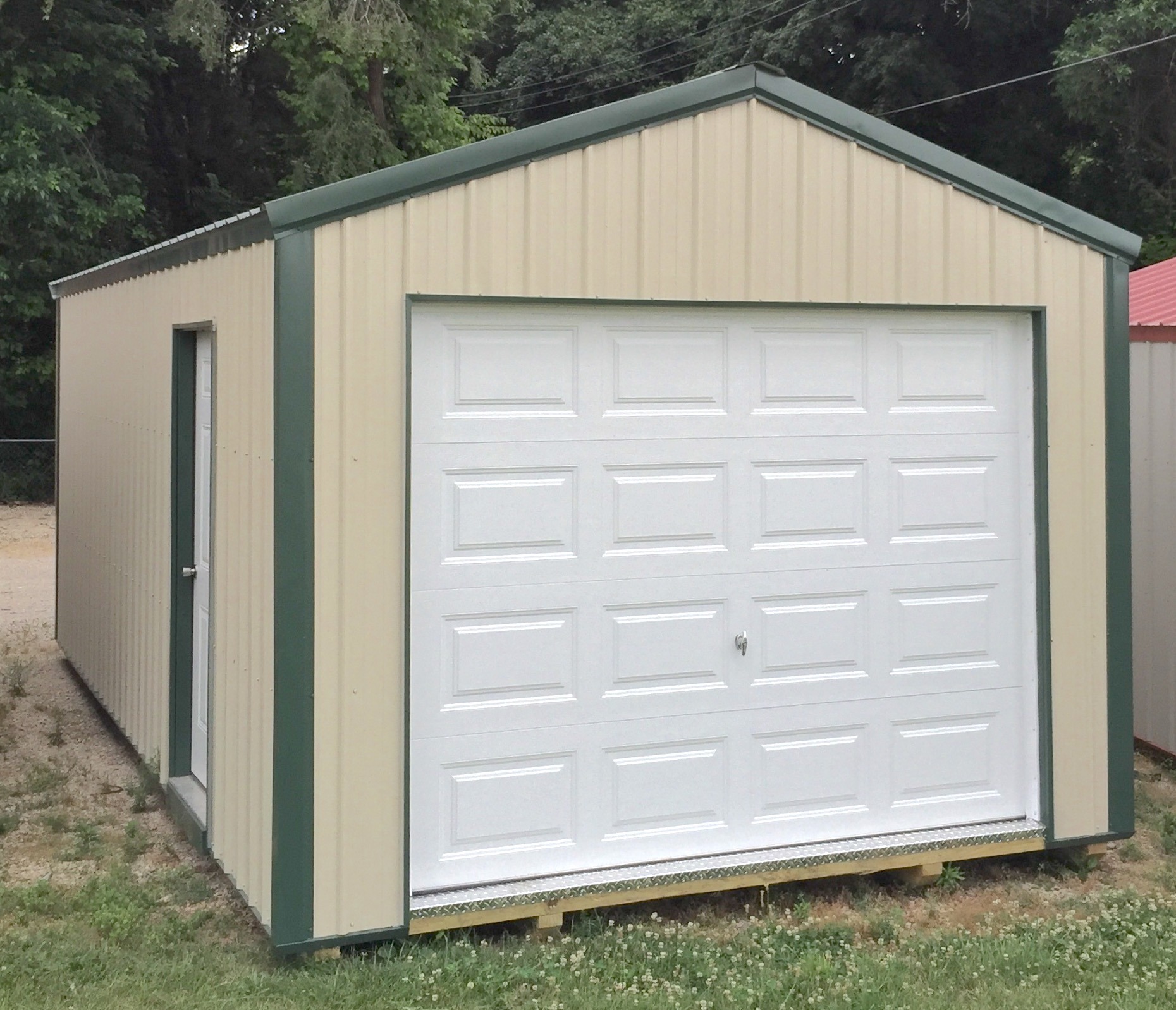 Tan metal garage with green trim and roof