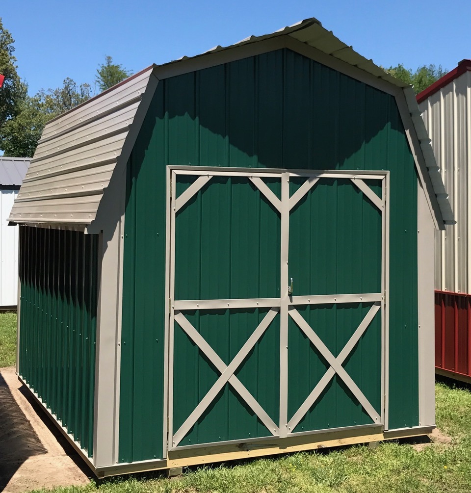 Green metal lofted economy shed with tan trim and roof