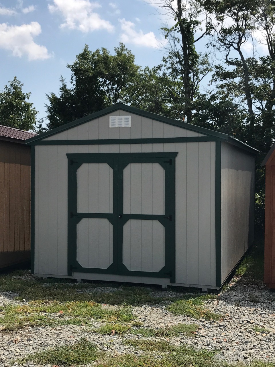 Tan painted express series utility shed with black trim