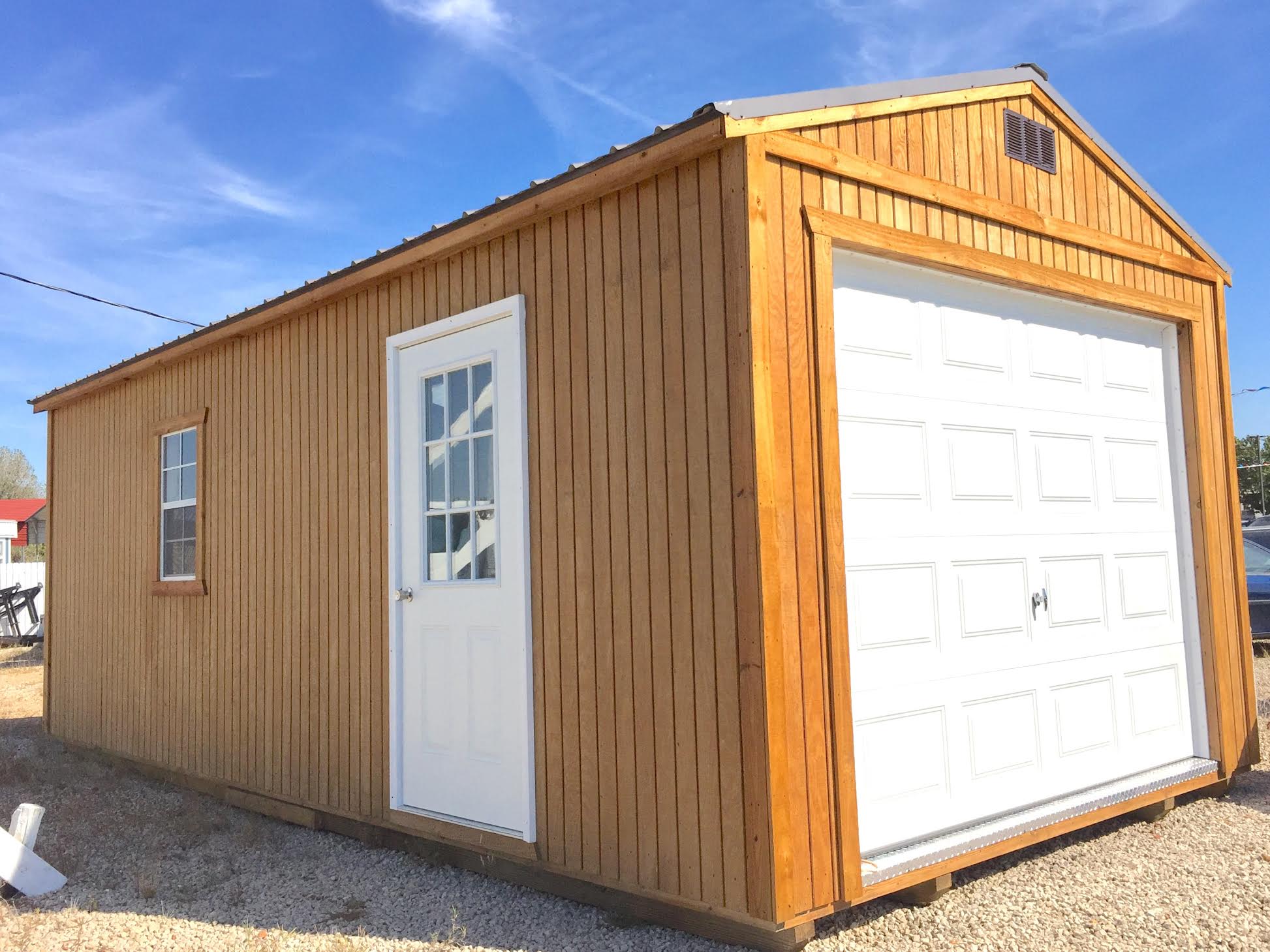 Treated light wood garage with white doors