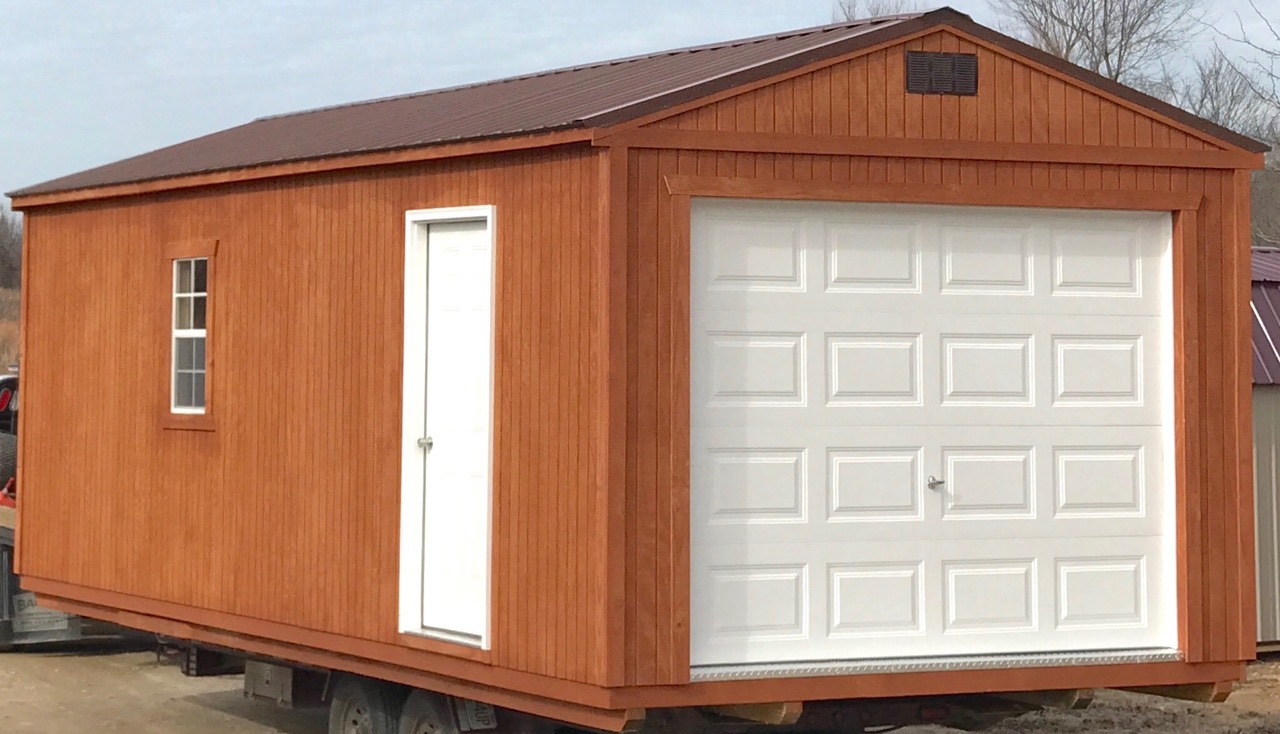 Treated wood garage with white doors and brown metal roof