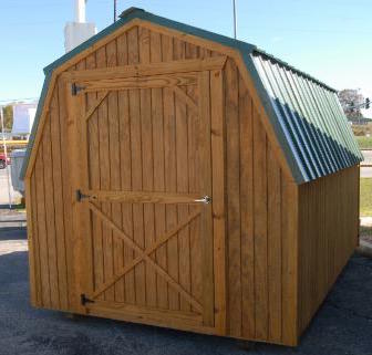 Treated wood mini barn with green metal roof