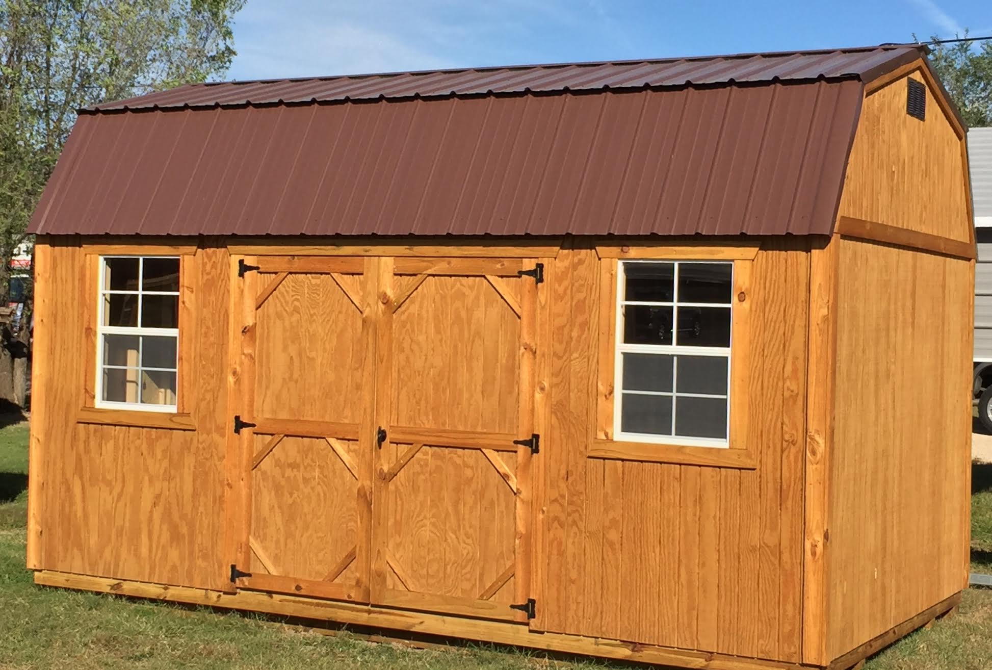 Light treated wood side lofted barn with brown metal roof