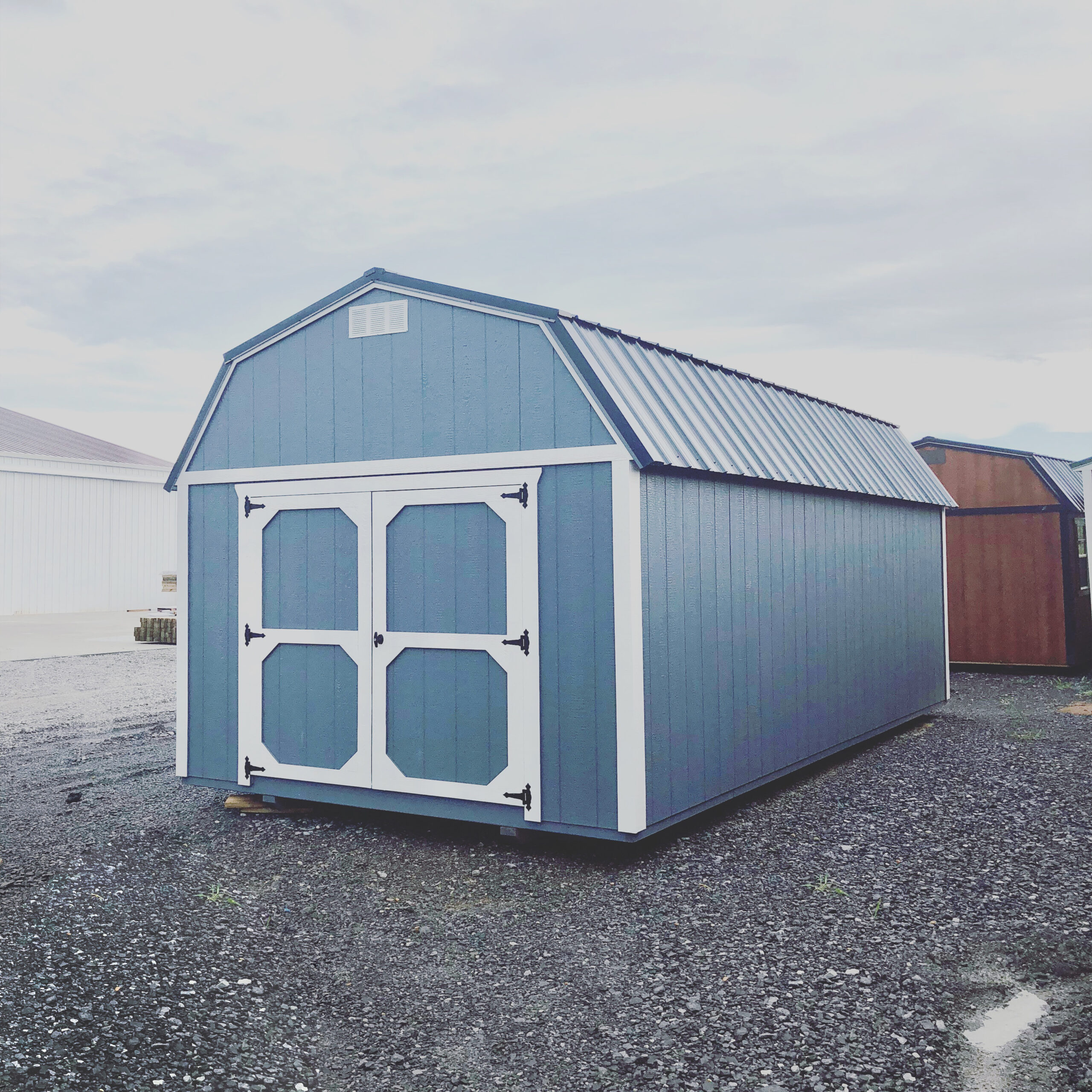 Blue lofted barn with white trim and metal roof