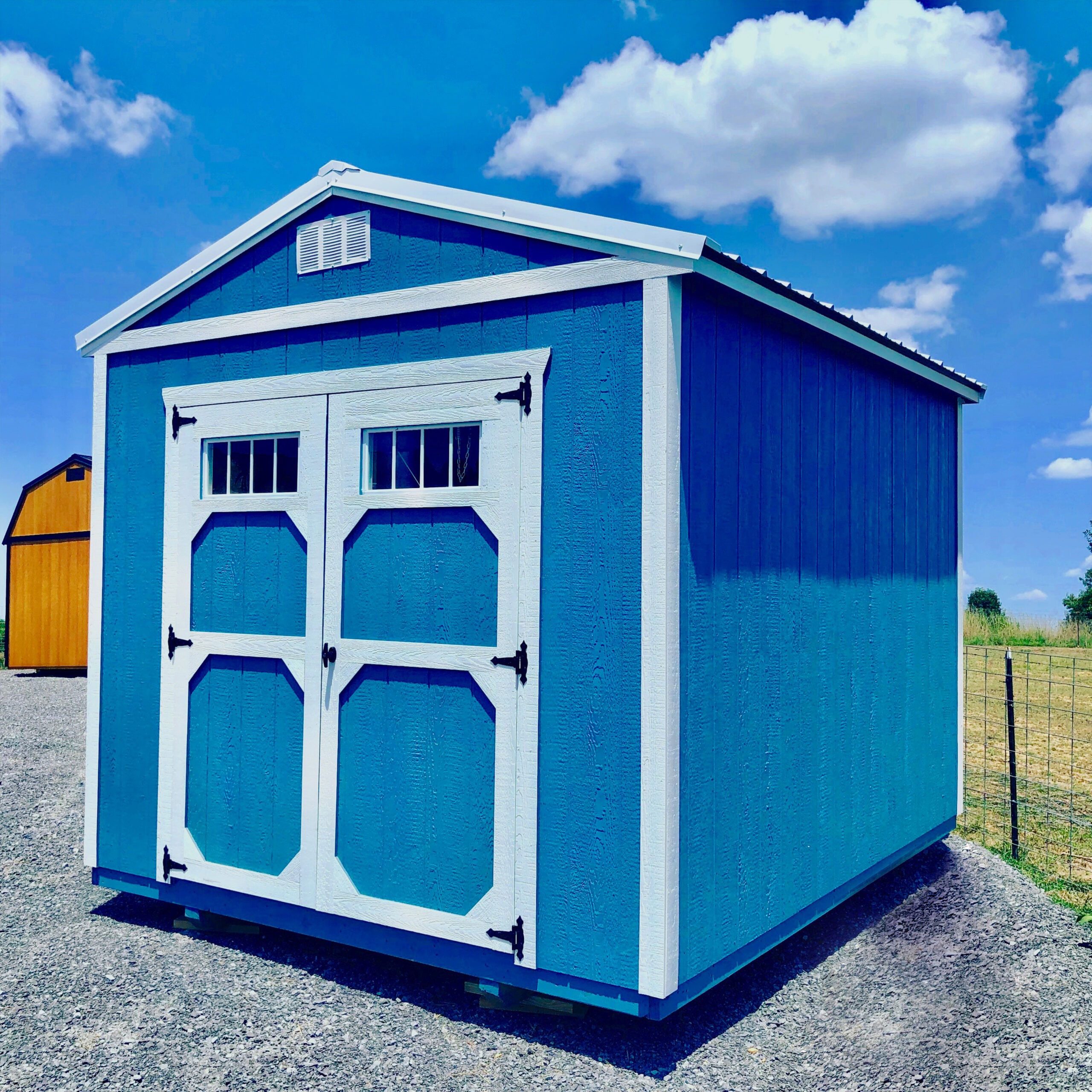 Blue utility shed with white trim