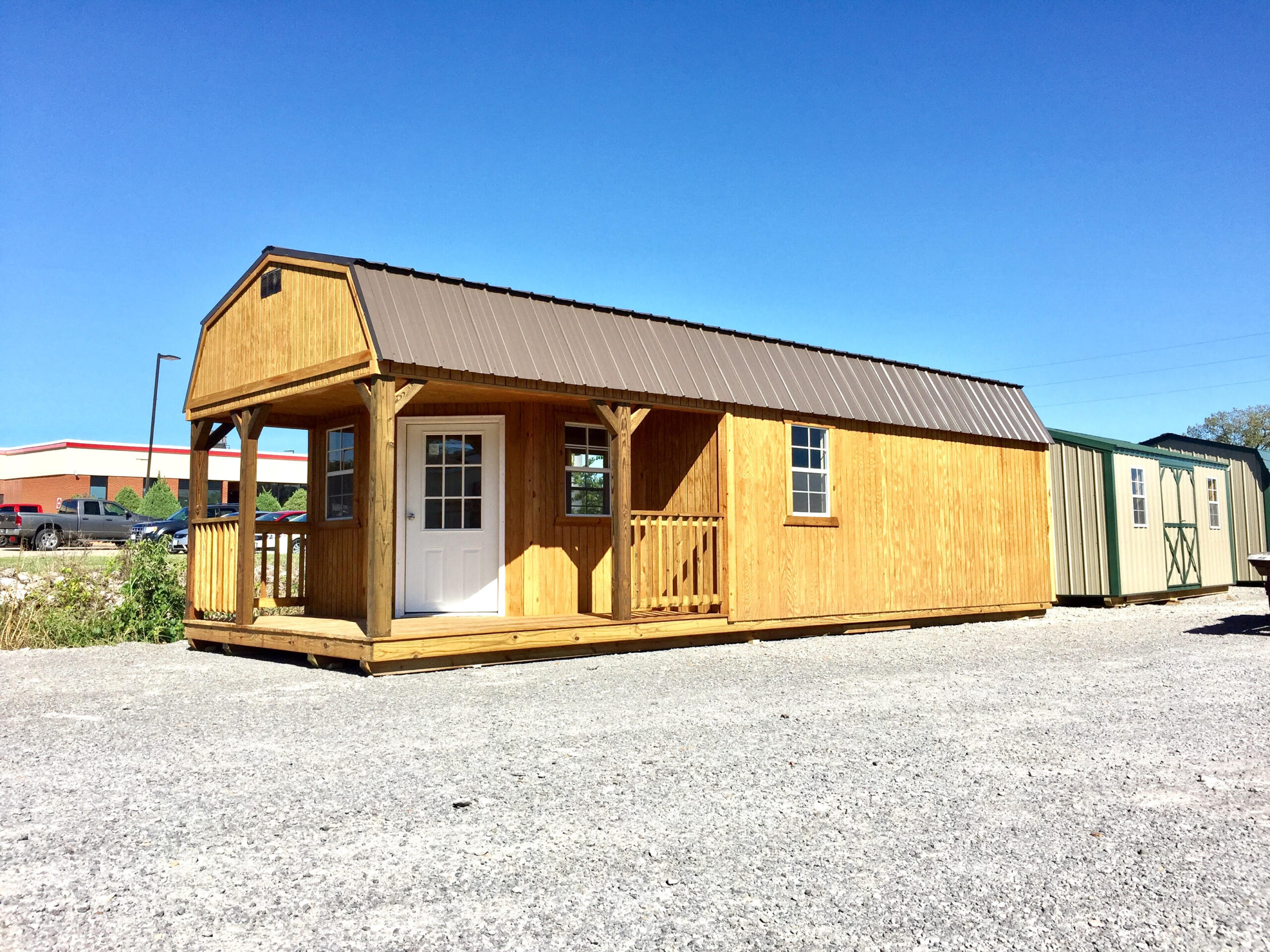 Premium lofted barn cabin with treated siding and wrap around porch